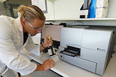 a researcher works with a plate reader in the lab
