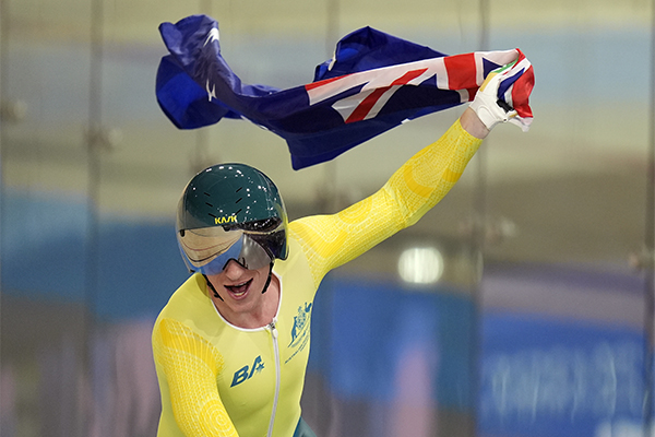 University of Queensland Cycle Club member Korey Boddington flies the Australian flag after winning a gold medal at the 2024 Paralympics in Paris.