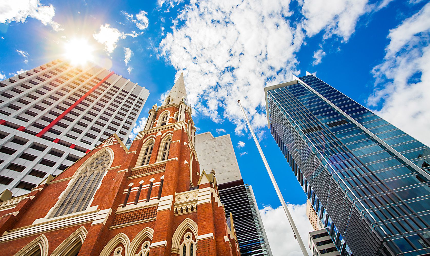 Historic Albert Street Uniting Church nestled among modern sky scrapers in Brisbane
