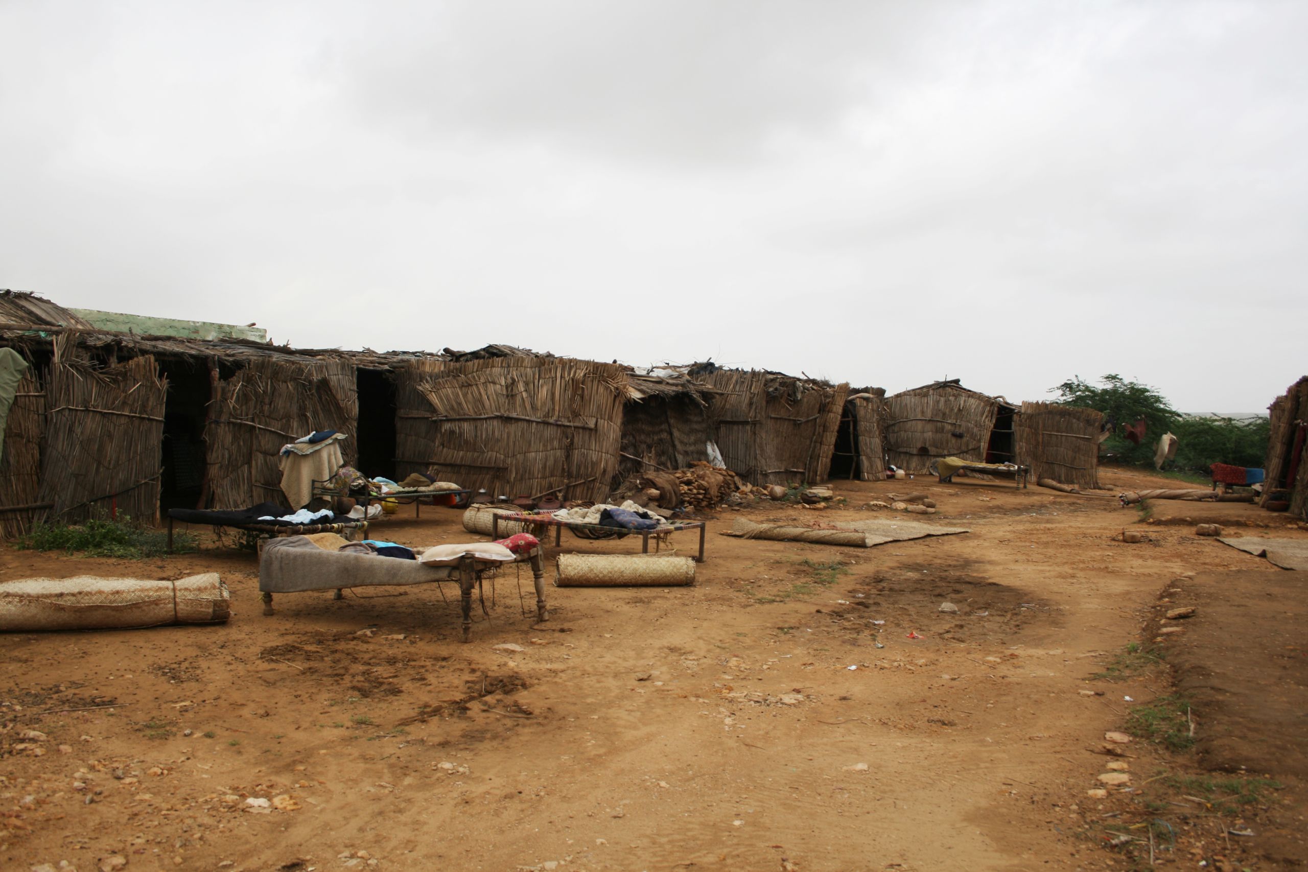 image of a third-world village with straw huts and derelict buildings