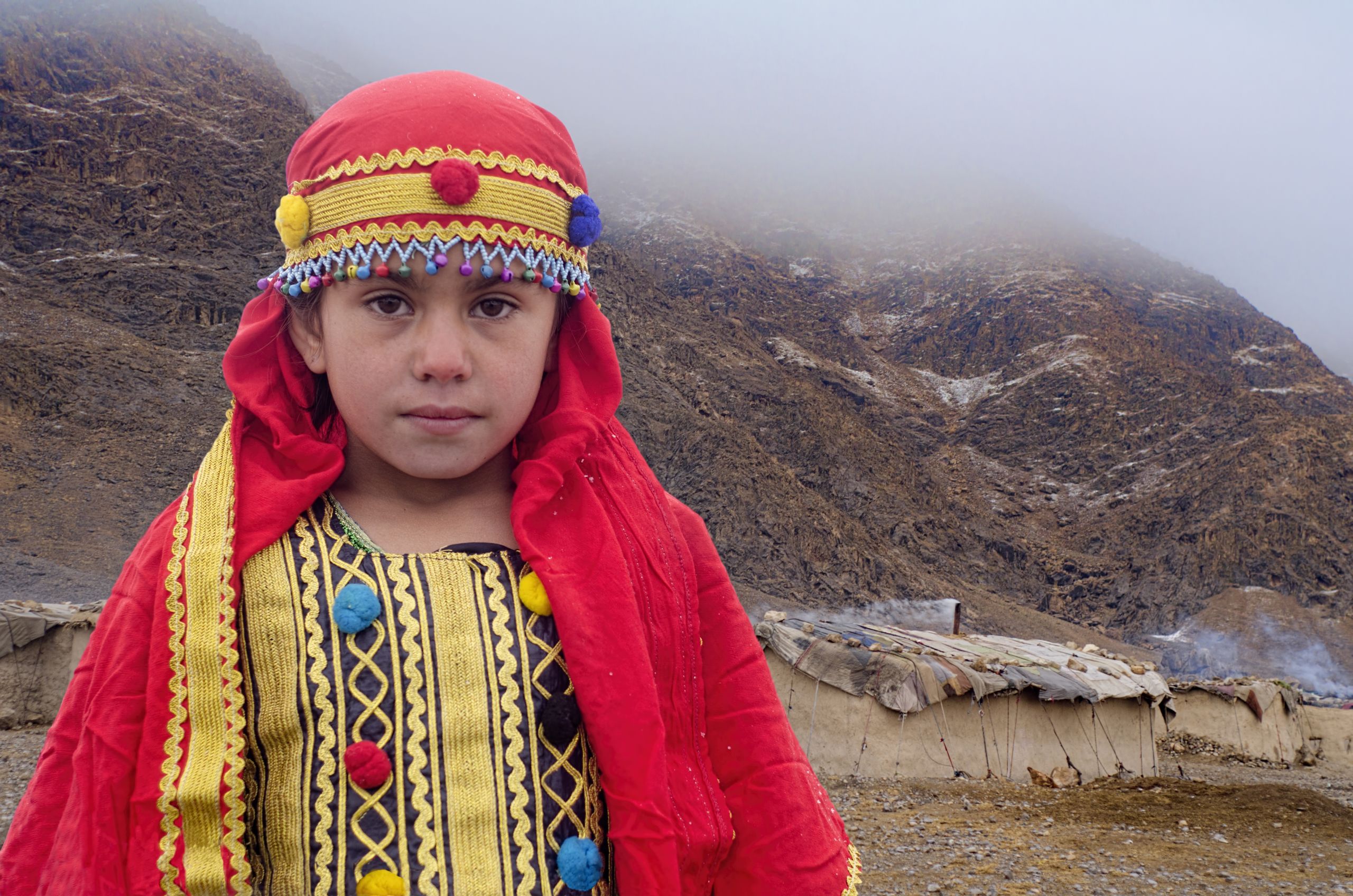 An Afghan refugee Girl Standing infront of her mud built house in freezing weather near Pakistan Afghanistan border in a Afghan Refugee camp