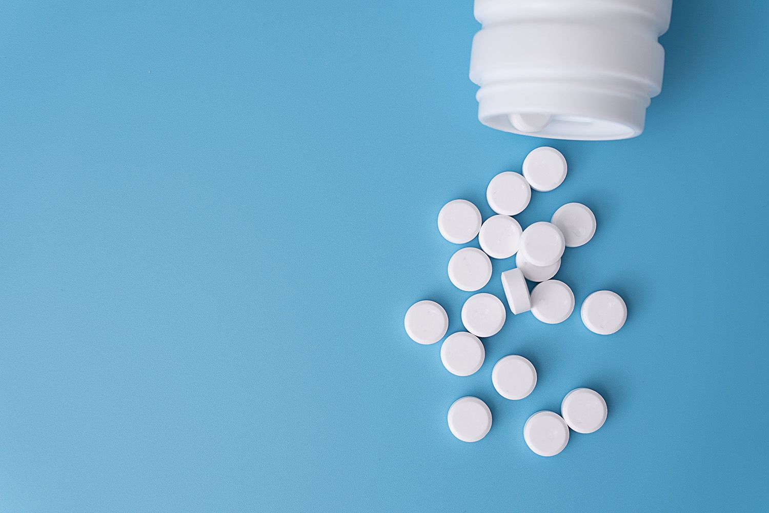 Pills spilling out of a bottle.