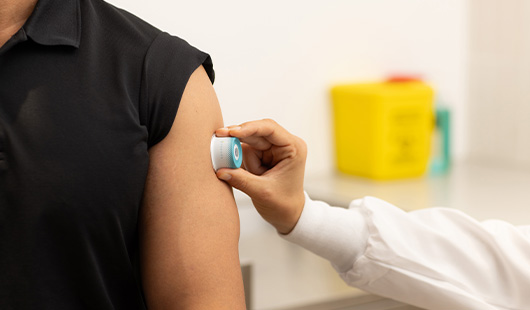 An image of the Vaxxas high-density microarray patch (HD-MAP) technology being administered onto a man's arm.