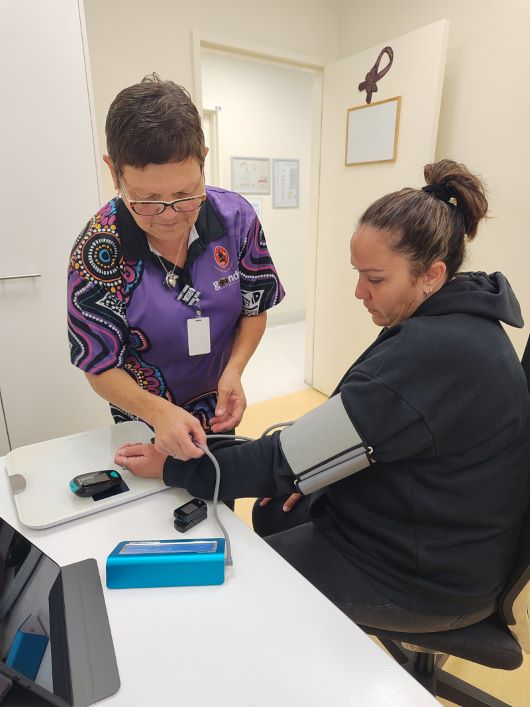A health professional monitoring the blood pressure of an Indigenous patient 