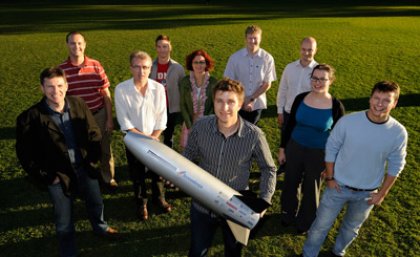 The SCRAMSPACE team with a smaller prototype of the 1.8m long hypersonic scramjet that will be available for public viewing on July 8 at UQ.