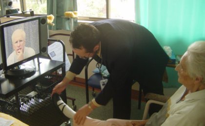 UQ Professor Len Gray consults with a resident in an aged care facility using telehealth.