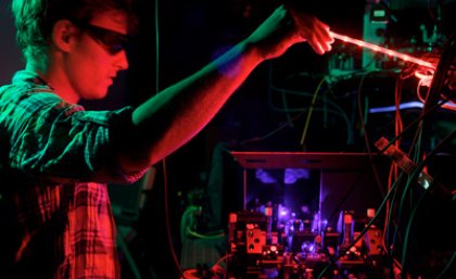 The University of Queensland's Dr Matthew Broome peering over the BosonSampling quantum computer.