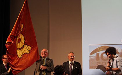 AMT Executive Director Professor Peter Taylor accepts the official IOI flag at this year’s closing ceremony held in Lake Garda, Italy, last month. Australia will be hosting next year’s Olympiad, to be held at UQ’s St Lucia campus. (Image courtesy of Daniel Graf)