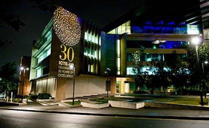 The exterior of the Sir Llew Edwards Building lit to celebrate ICTE-UQ's 30th anniversary
