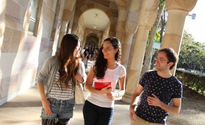 Photo of students in sandstone cloisters at UQ