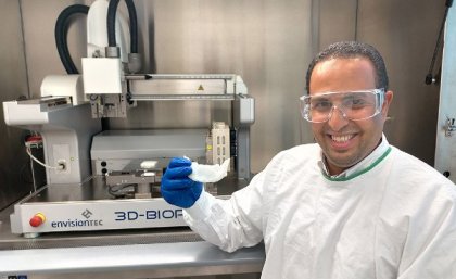 UQ researcher Dr Abdalla Ali holding a 3D-printed bone scaffold in a laboratory.