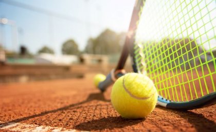 A low angle view of a tennis court, tennis racquet and ball