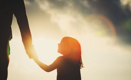 Image: Adobe A shadow of a little girl holding a parent's hand