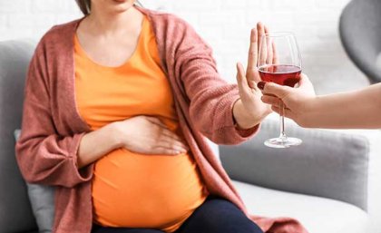 Image: Adobe pregnant woman holding up her hand to an alcoholic beverage