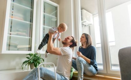 Young parents with dad holding toddler in air