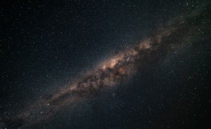A photograph of the night sky with the Milky Way galaxy stretching out.