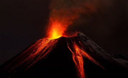 An erupting volcano at night. 