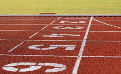 Red running track with white lines and number painted on.
