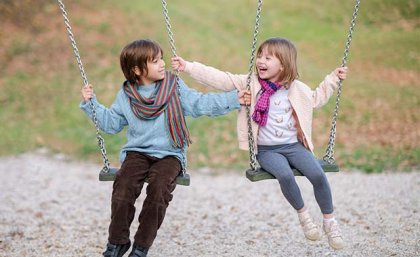 A boy and a girl swinging on swings