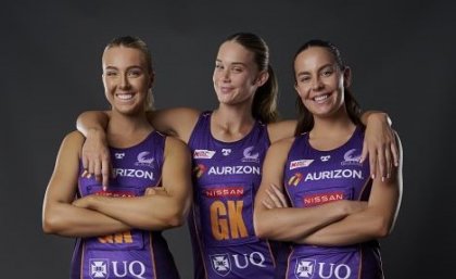 3 Firebirds players dressed in their purple netball uniforms smiling.