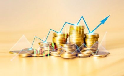 Stacked gold coins on an orange and gold background.