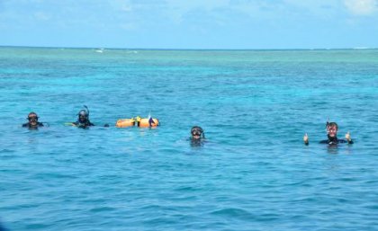 Divers with their heads out of very blue ocean water