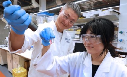 UQ researchers Dr Jingwei Hou and PhD scholar Yuelei Chen with liquified light conversion technology that will be used in wearable X-ray devices. UQ reseachers examining light conversion technology in a lab.