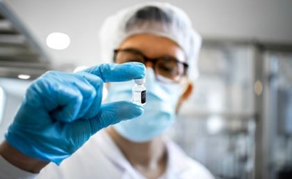 Image: Adobe. A man in a laboratory holds a vial up to his face
