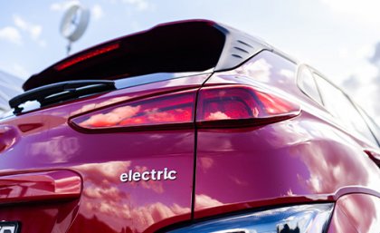 A photo of the back of a red car, with the word 'electric' on the bodywork.
