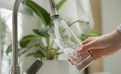 Image, Adobe. Person filling glass with water from tap. Adobe