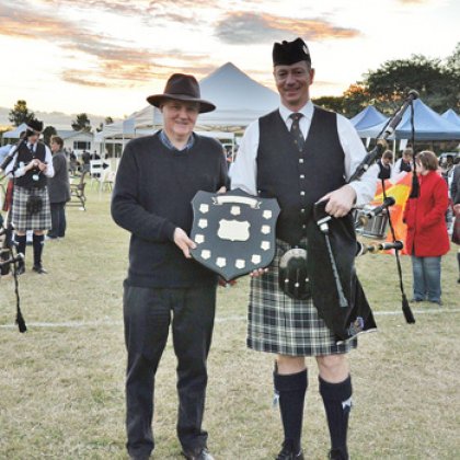 Adjunct Professor Stewart Gill and Pipe Major Andrew McCabe holding the Association Trophy that the UQ Pipe Band won at the 2012 Queensland Grade 4 Champions.