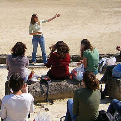 Dr Amelia Brown lecturing at an ancient stadium in Nemea, Greece