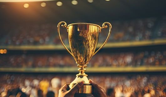 A gold trophy being help un in a stadium. 