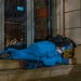 A homeless man asleep on the sidewalk