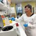 Professor Ranjeny Thomas. Professor Ranjeny Thomas wearing a lab coat and safety glasses working in the lab