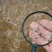 Microplastics in the environment can have adverse impacts on environmental and human health. Image: Adobe. Fingers holding microplastics shown through a magnifying glass