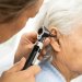 Image: Adobe A audiologist inserting a stethoscope into a elderly patient's ear