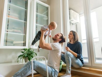 Young parents with dad holding toddler in air