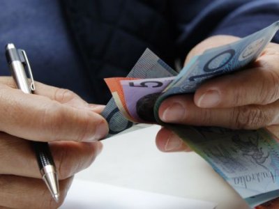 Close up of hands holding Australian dollar notes.