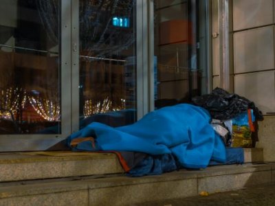 A homeless man asleep on the sidewalk