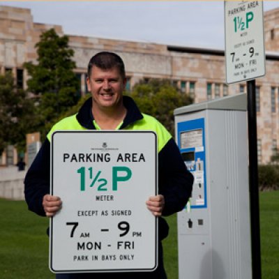 UQ Infrastructure Support Officer Gavin Campbell reveals the new campus parking signs that are in line with Brisbane City Council sign designs.