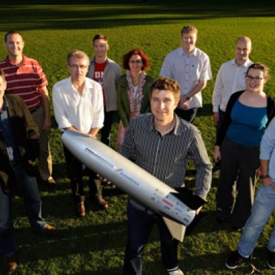 The SCRAMSPACE team with a smaller prototype of the 1.8m long hypersonic scramjet that will be available for public viewing on July 8 at UQ.