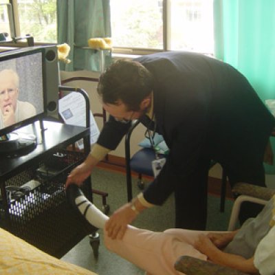 UQ Professor Len Gray consults with a resident in an aged care facility using telehealth.