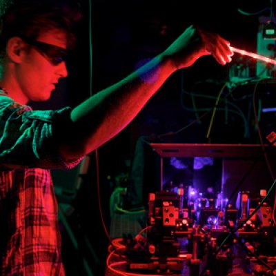 The University of Queensland's Dr Matthew Broome peering over the BosonSampling quantum computer.