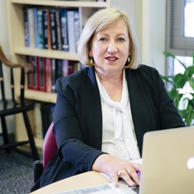 Professor Jennifer Stow sitting at a desk in front of a laptop