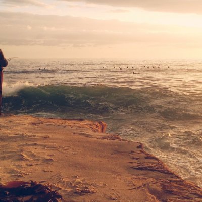 A fisherman fishes on the rocks