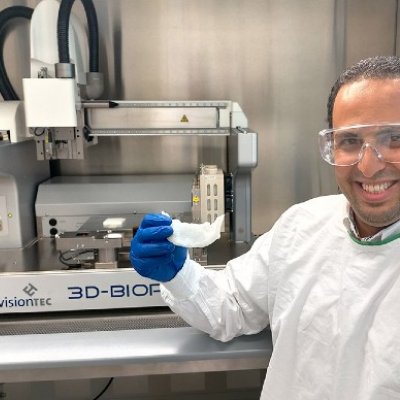 UQ researcher Dr Abdalla Ali holding a 3D-printed bone scaffold in a laboratory.