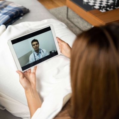 Woman staring at screen with doctor on it 