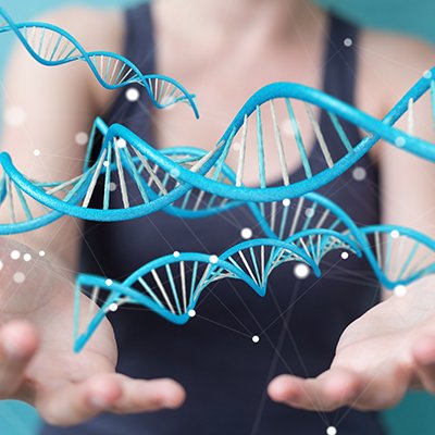 A woman stands in front of a blue background with graphic depiction of DNA