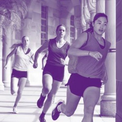 Three female athletes running around sandstone building with purple overlay.